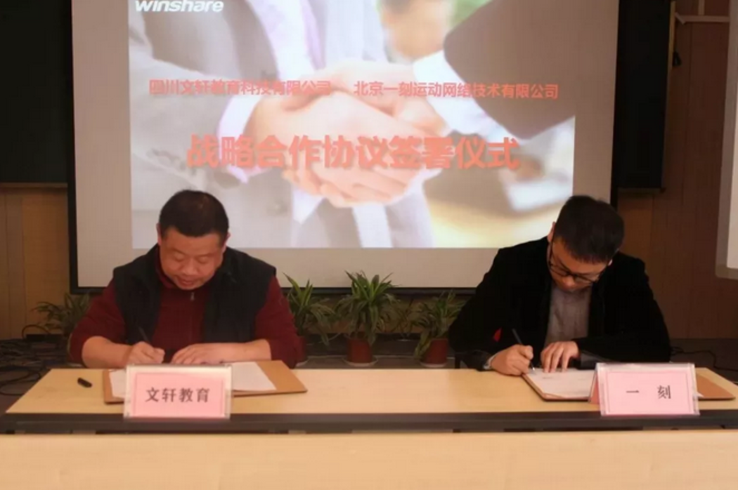 四川文轩总经理杨念（左）与一刻足球运营总监屈广雅（右）签署合作协议